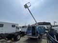 A blue 2005 Ford Econoline with an elevated hydraulic lift extending from the roof