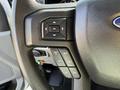 Close-up of a 2021 Ford F-250 SD steering wheel control panel featuring buttons for setting speed and adjusting settings