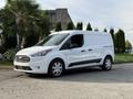 A white 2020 Ford Transit Connect van with a sleek design and side sliding door parked on a driveway