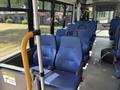 The interior of a 2020 Chevrolet Express showing blue seats with a handrail and a caution sign on the side
