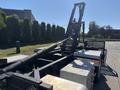 A 2020 Peterbilt 330 truck featuring a flatbed with a loading arm and silver checker plate surfaces