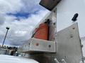 A close-up of a 2015 Ford F-550 featuring a mounted orange tank on a metallic bracket