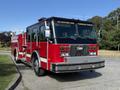 A red 1992 Emergency One Typhoon Superior fire truck with chrome accents and a shiny front grille displaying the fire department emblem.