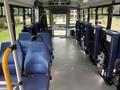 Interior of a 2020 Chevrolet Express bus featuring blue seats arranged in rows with secure areas for wheelchairs and a clear pathway down the middle