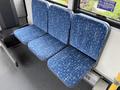 A row of three blue bus seats with a patterned fabric design displaying various shapes and colors