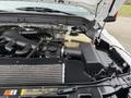 Engine compartment of a 2012 Ford F-550 showing various engine components including air intake hoses and coolant reservoir