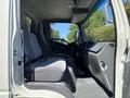 A 2016 Isuzu NPR-HD with two gray cloth seats and a dashboard featuring multiple controls and displays
