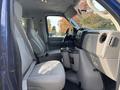 Interior view of a 2013 Ford E-350 Super Duty showing two gray front seats and a dashboard with controls and cup holders