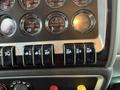 Close-up of the dashboard controls of a 2018 Kenworth T800 showing various gauges and toggle switches for vehicle functions