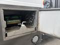 A partially opened compartment on a 2020 Chevrolet Express revealing an Interstate battery and various electrical connections
