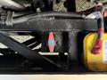 A close-up view of a control valve with a red handle and a blue indicator on a black metal frame alongside a yellow electronic component