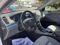 Interior of a 2014 Hyundai Sonata featuring a steering wheel center console and seats with a gray and black color scheme