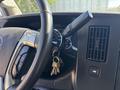 Close-up of the steering wheel with ignition keys attached and dashboard controls in a 2019 GMC Savana