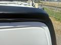 A 2017 Chevrolet Express van with a black rubber trim along the roofline and a white body