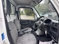 Interior view of a 2008 Suzuki Carry showing the driver's seat gear stick and dashboard with gray fabric seats and a clean layout