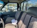 Interior of a 1996 GMC Top Kick showing a bench seat covered in patterned fabric with a white shirt and a cup on it