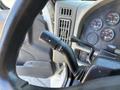 Close-up of the turn signal lever on the steering column of a 2011 International 4300 with visible instrument panel gauges in the background