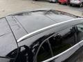 A black 2016 Mercedes-Benz GLA-250 with a sleek design featuring a shiny silver roof rail and a smooth roof surface covered in raindrops