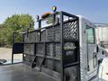 A 2020 Peterbilt 330 truck with a roll-off system attached featuring a metal frame and a lattice design on the sides