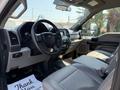 Interior of a 2018 Ford F-550 featuring a steering wheel dashboard and front seats in a light color scheme