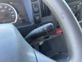 Close-up of a steering column with controls for wipers and lights in a 2022 Isuzu NQR truck interior