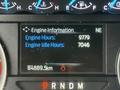Dashboard display of a 2020 Ford F-550 showing engine information with total engine hours listed as 9779 and idle hours as 7046 along with odometer reading of 84889.5 km