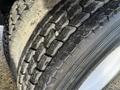 Close-up of a tire from a 2010 International 4300 showing tread patterns with some dirt and wear visible on the surface