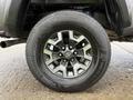 Close-up of a wheel and tire on a 2016 Toyota Tacoma featuring a silver and black rim design and all-terrain tire tread