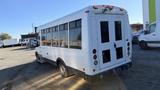 A 2021 Ford Transit with a white exterior featuring large windows and two rear doors positioned for easy access