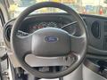 Steering wheel of a 2008 Ford Econoline featuring the Ford logo and various controls including a gauge cluster behind it