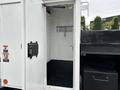 A 2013 Freightliner 114SD with an open side compartment revealing a partially empty interior with a single metal bar along the side