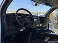Interior of a 2014 Chevrolet Express showing the steering wheel dashboard controls and gear shifter