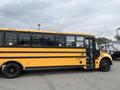 A yellow 2007 Freightliner B2 school bus with black stripes and multiple windows on the side