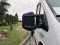 A 2023 RAM Promaster 3500 van with a side mirror featuring a black housing reflecting raindrops on its surface