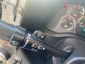 A close-up of the control stalk inside a 2011 Chevrolet Express featuring various toggle switches for wipers and lights