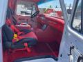 Interior of a 1962 Ford 2WHDR featuring red seats with harnesses a red dashboard and a touchscreen display