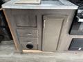 A section of a 2021 Jayco Jay Flight camper interior features a countertop with a sink and storage drawers, including a cabinet door and an air vent below