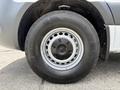 Close-up of a silver alloy wheel of a 2022 Mercedes-Benz Sprinter featuring a distinctive wheel design and a rugged tire