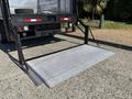 A 2019 Ford F-550 with a lowered loading ramp in the rear for transporting goods