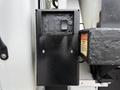 A black control box with two switches mounted on a vehicle, indicating functions for up and down operations with a warning label nearby
