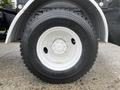 Close-up of a white rim with a black tire mounted on a 2016 Freightliner 108SD showing tread pattern and sidewall markings