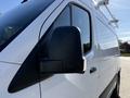 A close-up of the driver's side mirror of a 2023 Mercedes-Benz Sprinter 2500 van showing a modern black mirror housing and sleek design