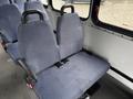A pair of blue upholstered bus seats with seatbelts attached sitting in the interior of a 2018 Chevrolet Express