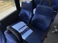 Two blue upholstered seats in a Chevrolet Express with seat belts visible on each seat
