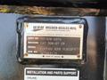 A metal identification plate attached to a Caterpillar 306 machine displaying its model number assembly number and serial number