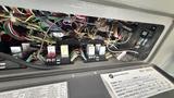 Interior view of a 2021 Ford Transit electrical panel showing various colored wires and relays connected to a control module