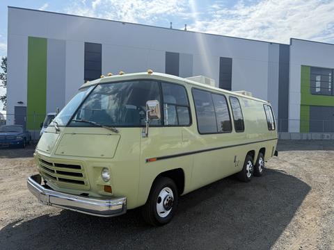 A 1976 GMC Motorhome with a distinctive yellow exterior and large windows featuring a sleek design and prominent front grille