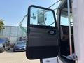 A 2008 Peterbilt 340 truck with its driver's door open showcasing the interior dashboard and controls
