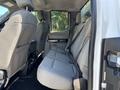 Interior view of a 2017 Ford F-550 showing two rows of gray upholstered seats and seatbelts without any occupants