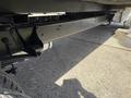 View of the underside of a 2023 Ford E-450 showcasing the chassis and suspension components with a focus on the frame along the length